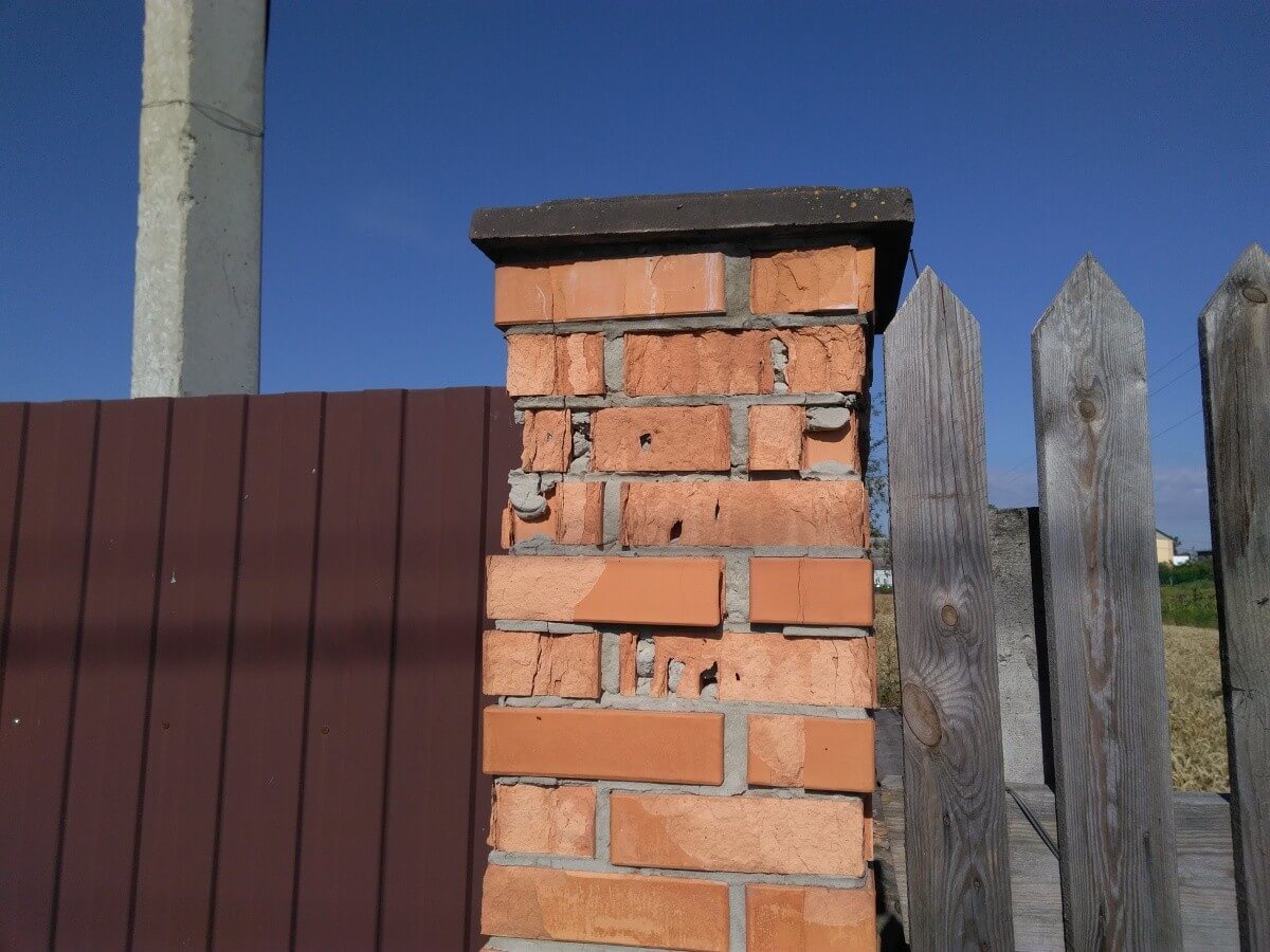 Кирпичный столб забора с поздно установленным колпаком Кирпичный столб забора с поздно установленным колпаком