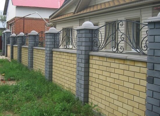 Крышки с полусферой на столбах забора из кирпича