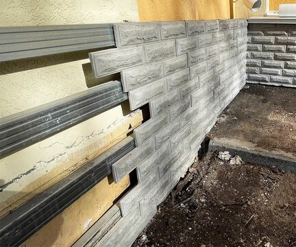 Облицовка цоколя здания бетонной сайдинговой панелью-вилкой «Ростовский камень». Облицовка цоколя здания бетонной сайдинговой панелью-вилкой «Ростовский камень».