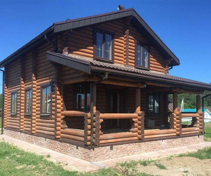Дом из цельного бревна с цоколем, отделанным бетонной плиткой Дом из цельного бревна с цоколем, отделанным бетонной плиткой